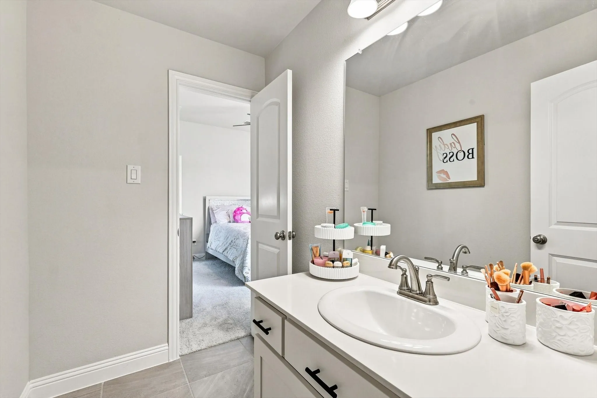 Vanity with an integrated oval sink, white countertop, and brushed nickel faucet
