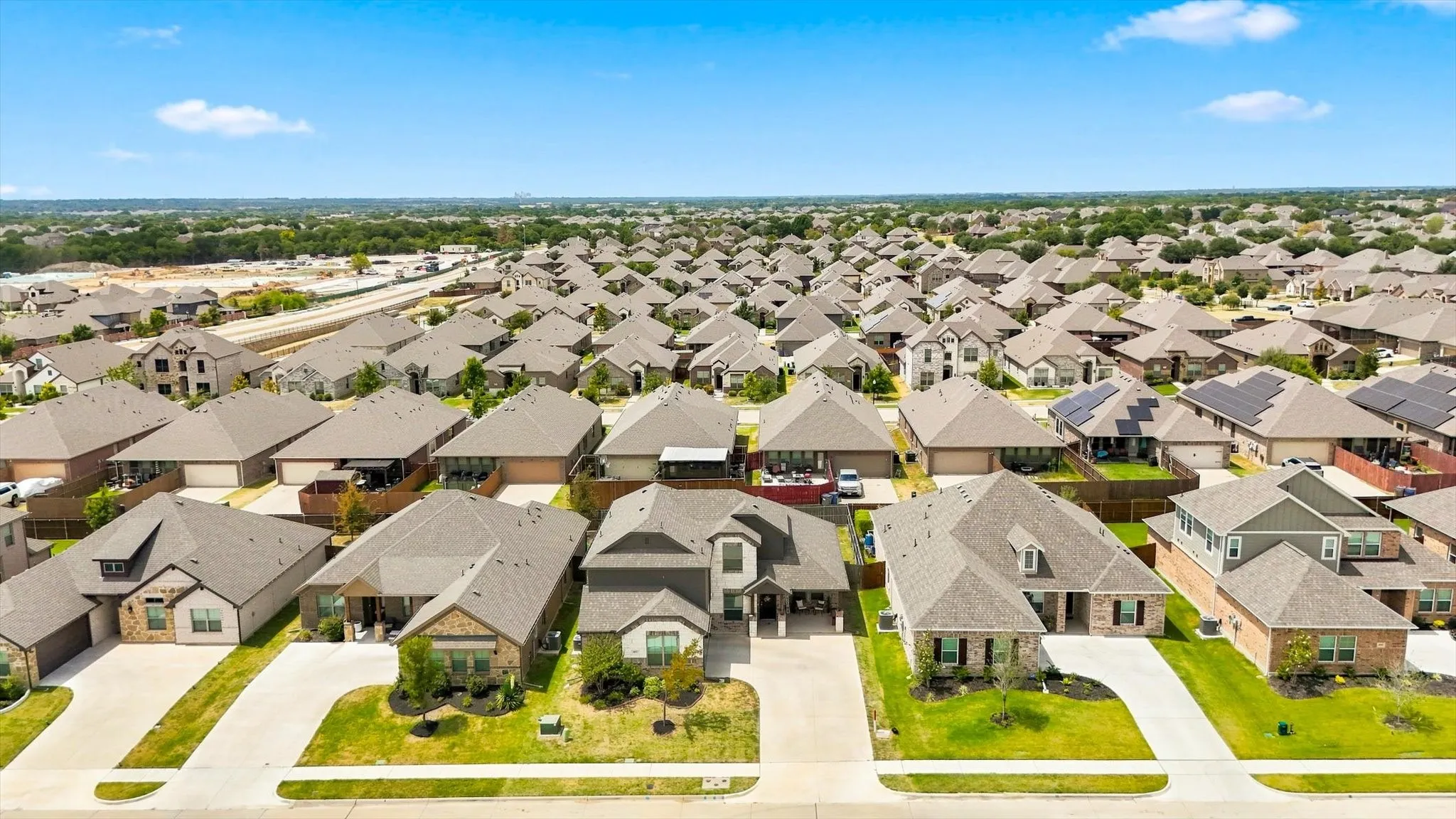 Residential community featuring a variety of single-family homes with pitched roofs and attached garages