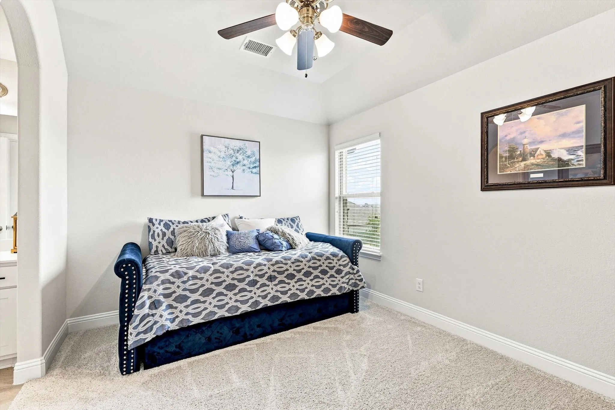 Recessed window with blinds, ceiling fan with integrated lighting, and neutral carpeting