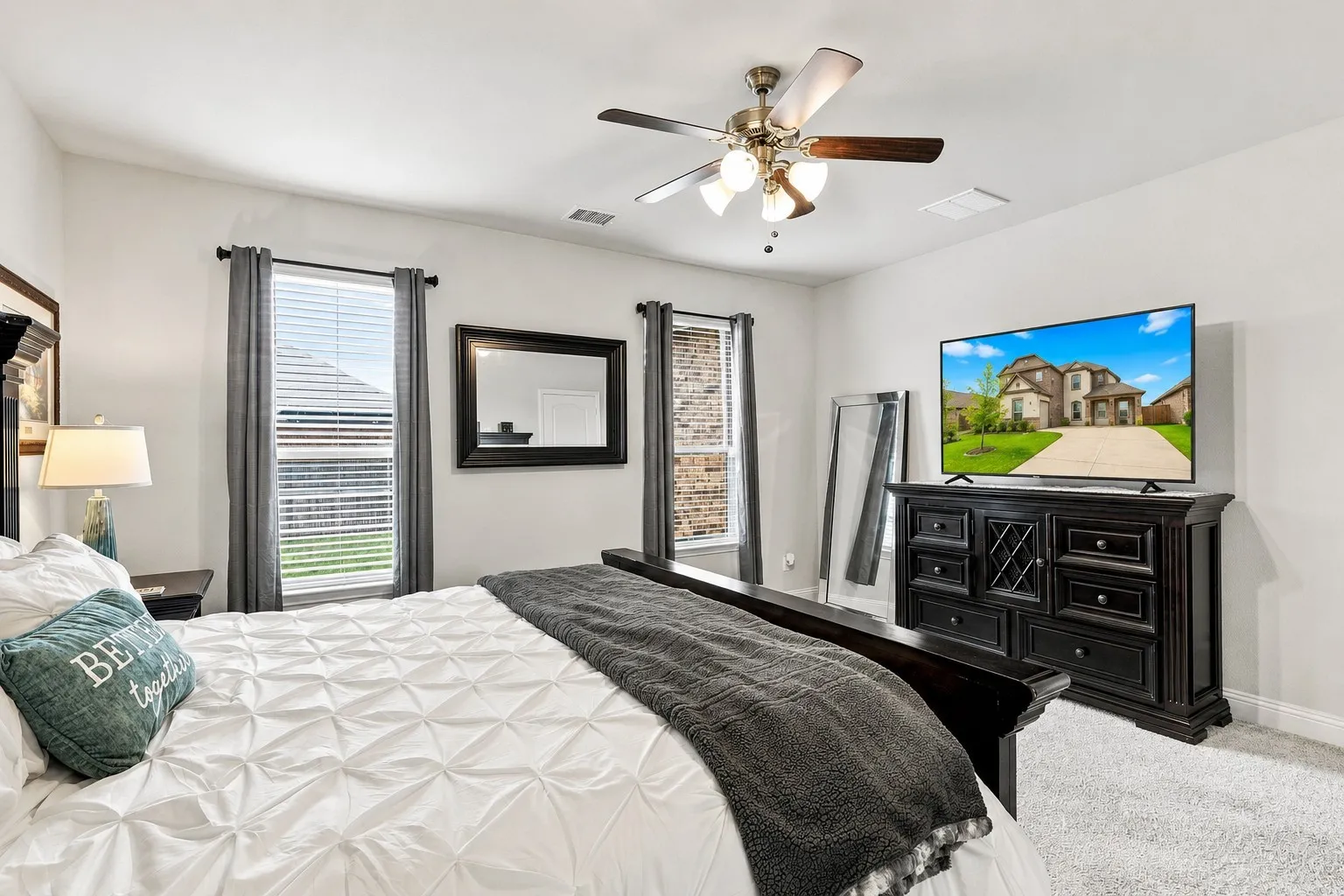 Light-colored walls, wood-finish ceiling fan, and carpeted flooring