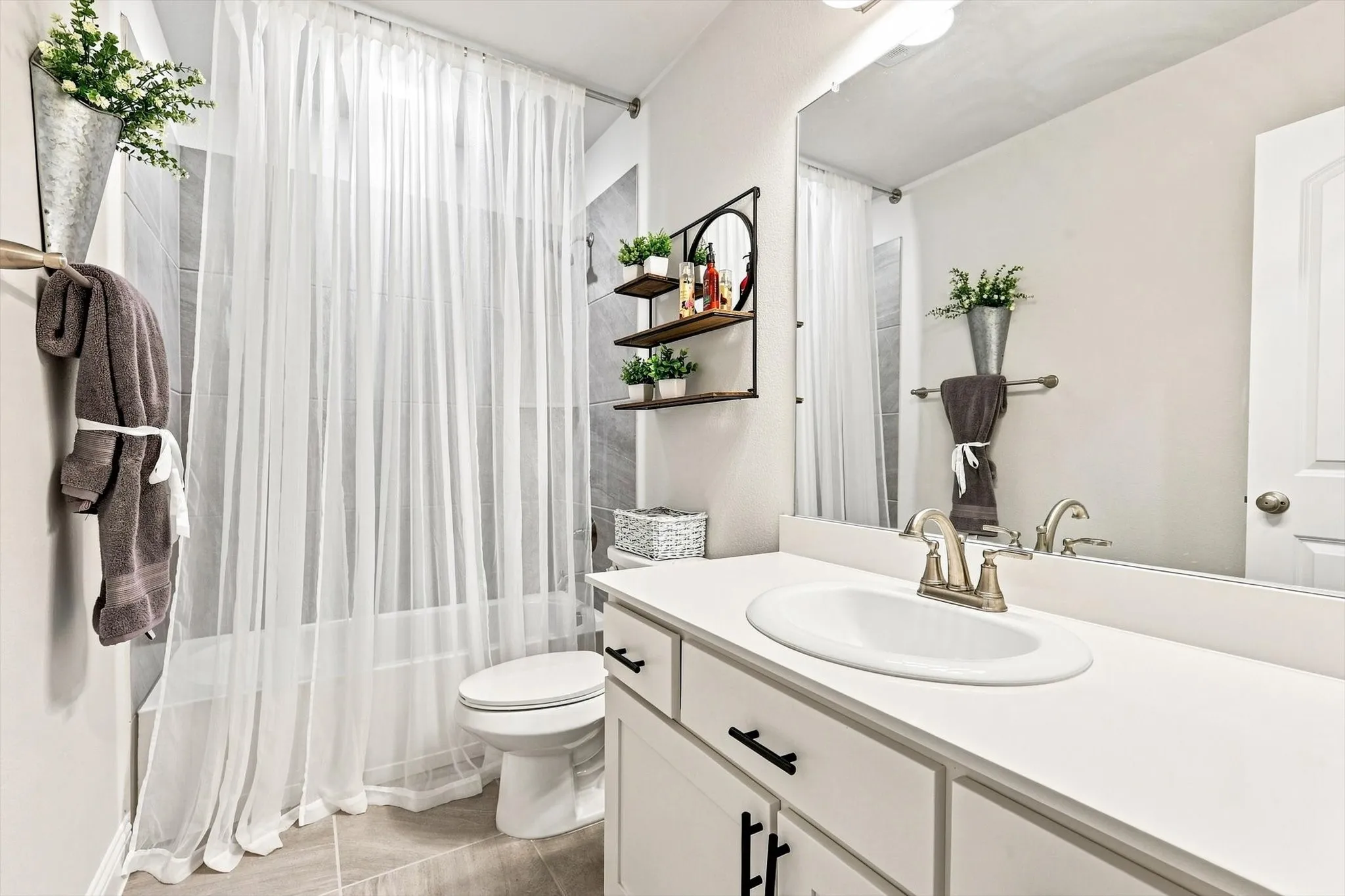 Vanity with an integrated sink, brushed nickel faucet, and a large wall-mounted mirror