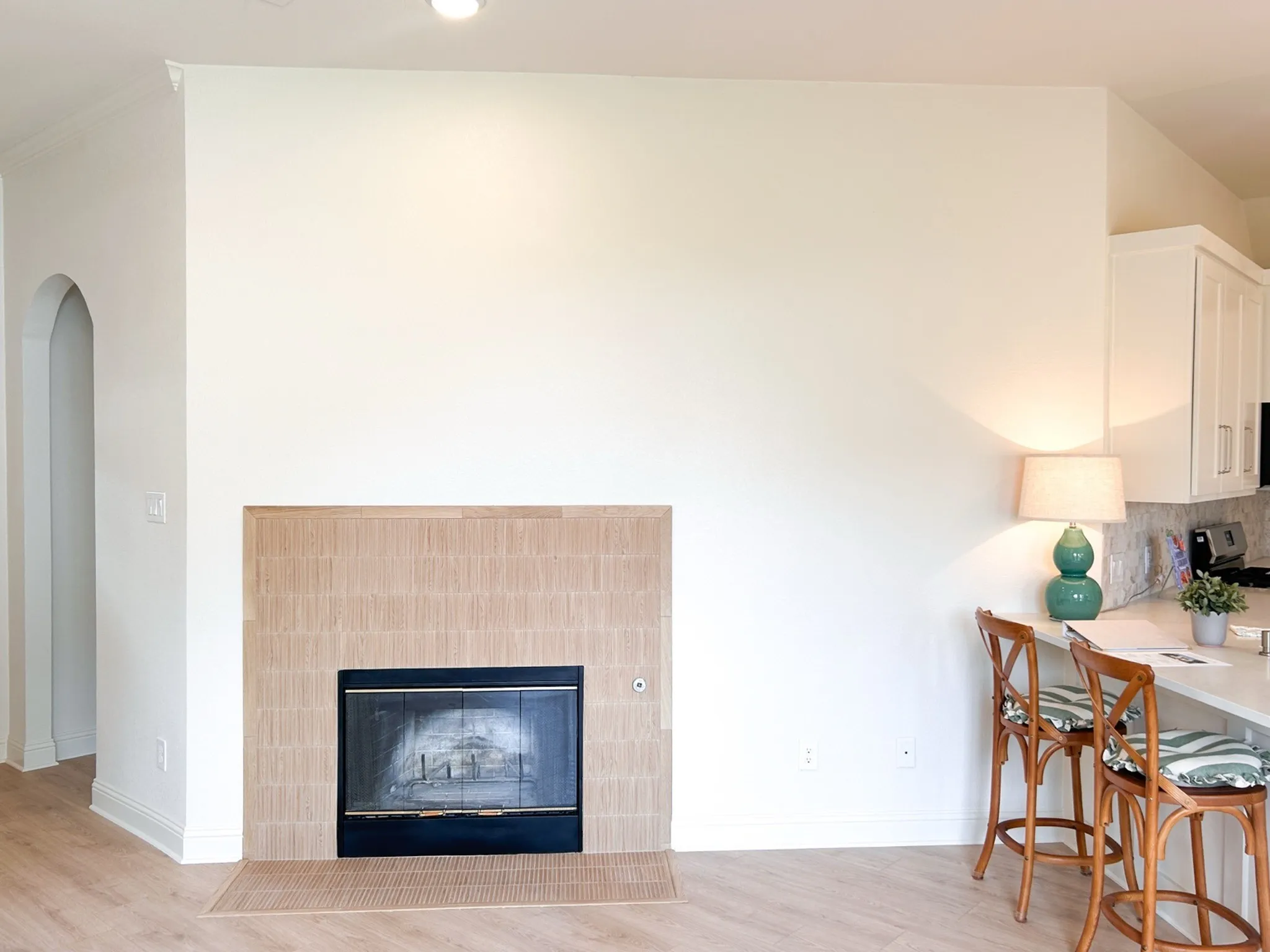 Updated living area featuring a modern tiled fireplace, breakfast bar seating, and an open-concept layout connecting to the kitchen.