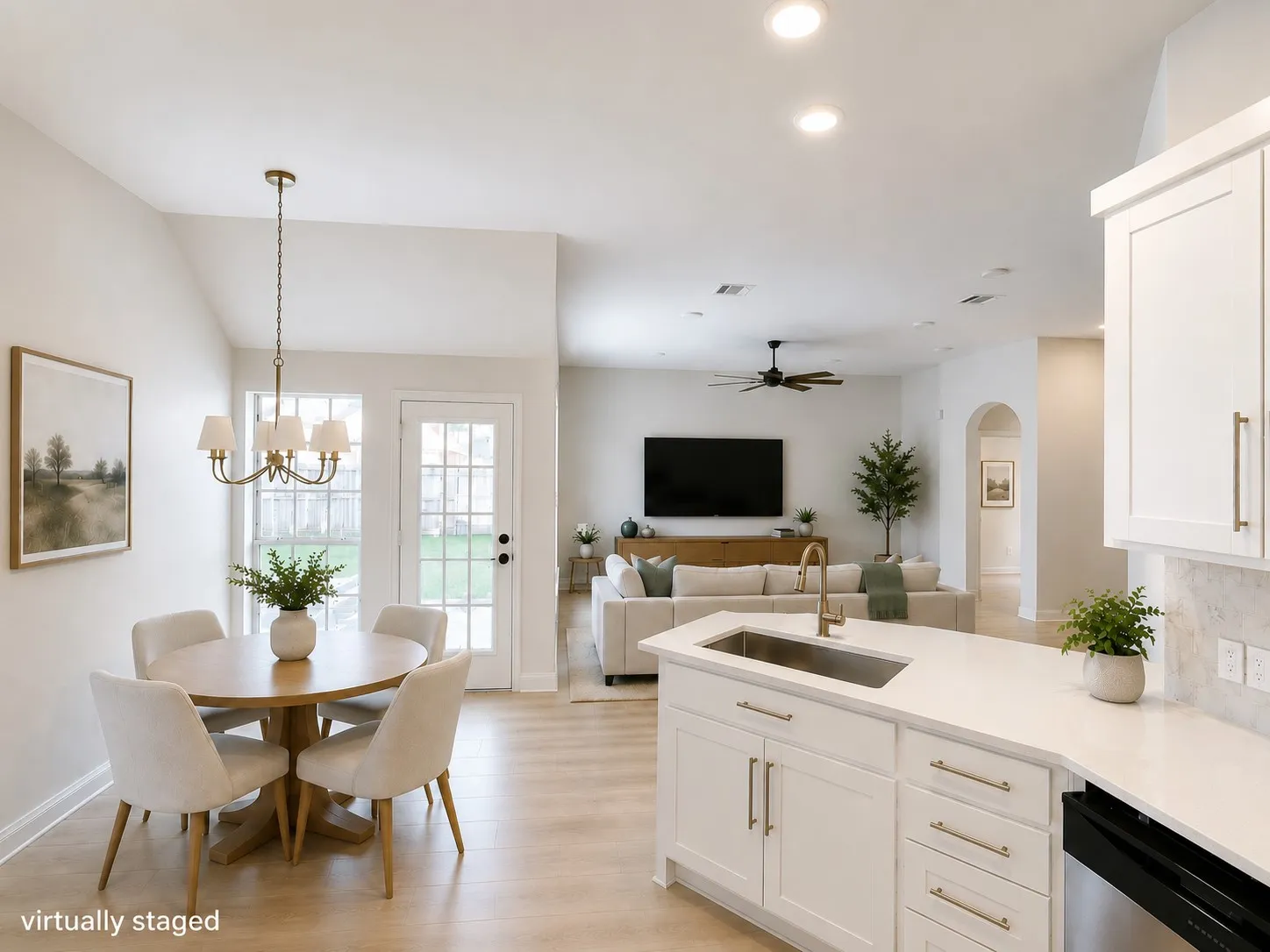 Bright, open-concept kitchen and living area with a large island, quartz countertops, stainless steel sink, custom cabinetry, and seamless flow for everyday living and entertaining.