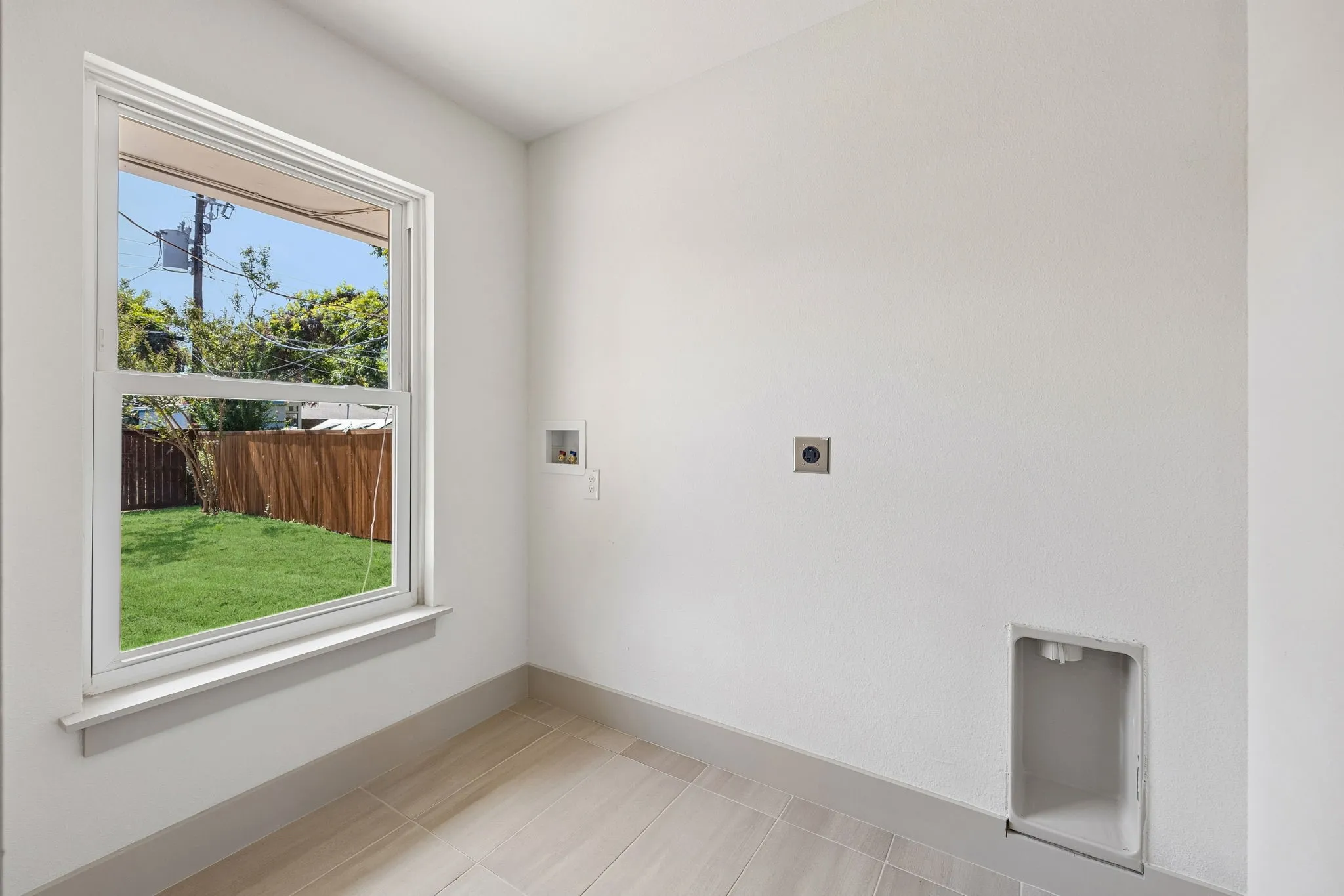 Window with white trim, light-toned tile flooring, and neutral wall finish