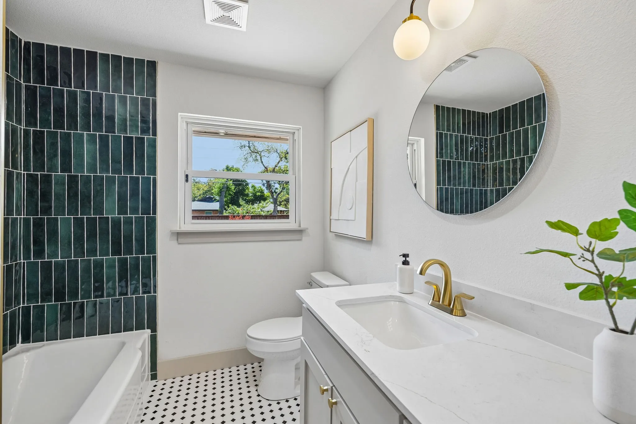 Bathroom featuring a white bathtub, dark green vertical tile surround, black and white hexagonal floor tiles, and a window