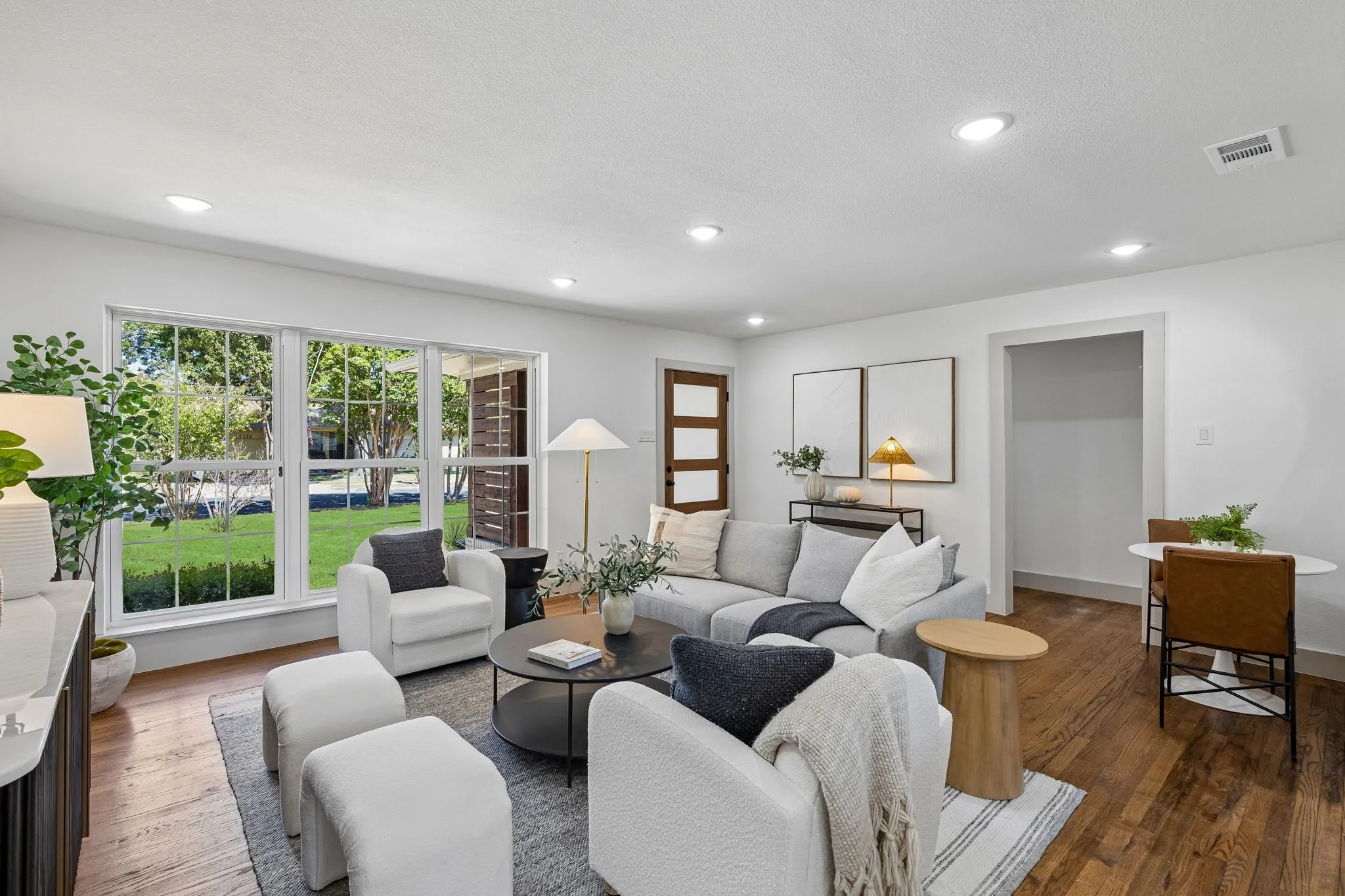 Spacious living area featuring large windows, recessed lighting, and wood-finish flooring
