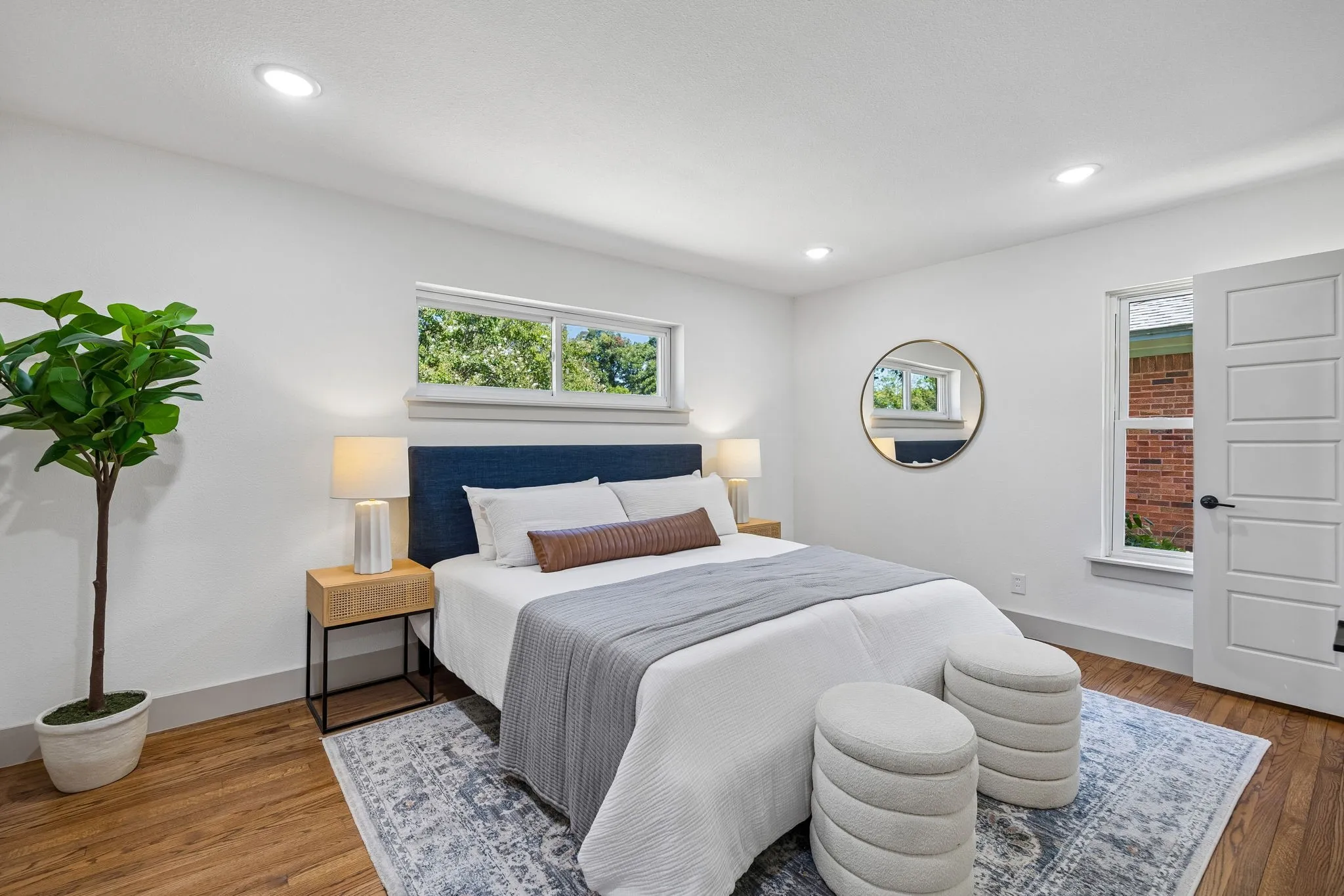 Recessed lighting, wood-finish flooring, white walls, multiple windows, and a five-panel interior door