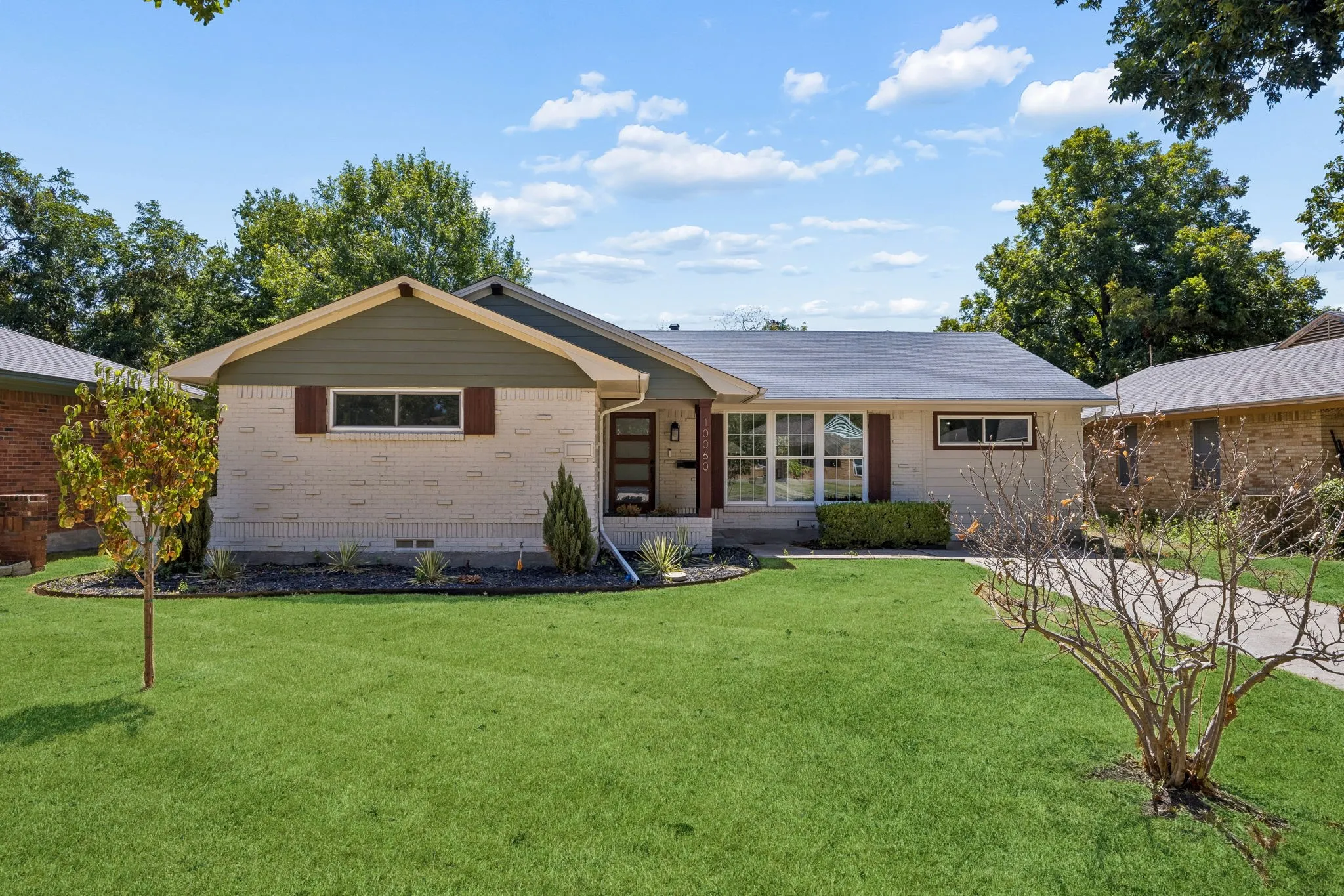 Single-story residence featuring light-colored brick and horizontal siding accents