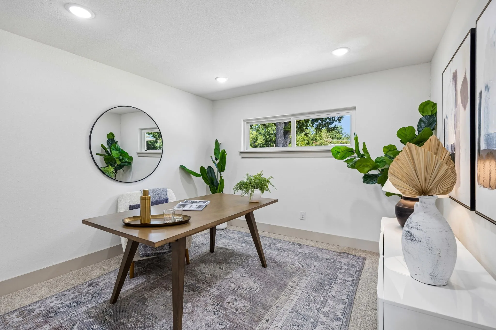 Recessed ceiling lighting, horizontal window, white walls, and light-colored flooring