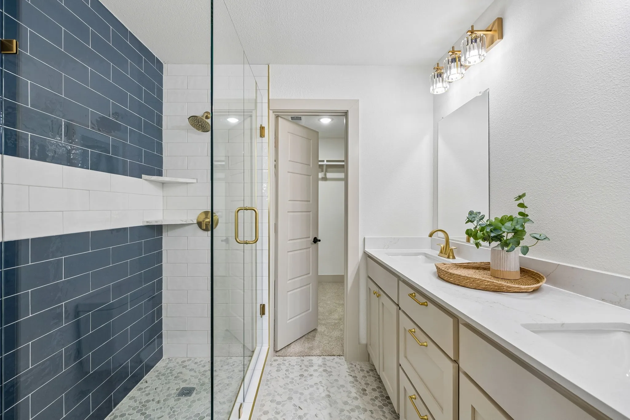 Walk-in shower with full glass enclosure and gold-tone fixtures