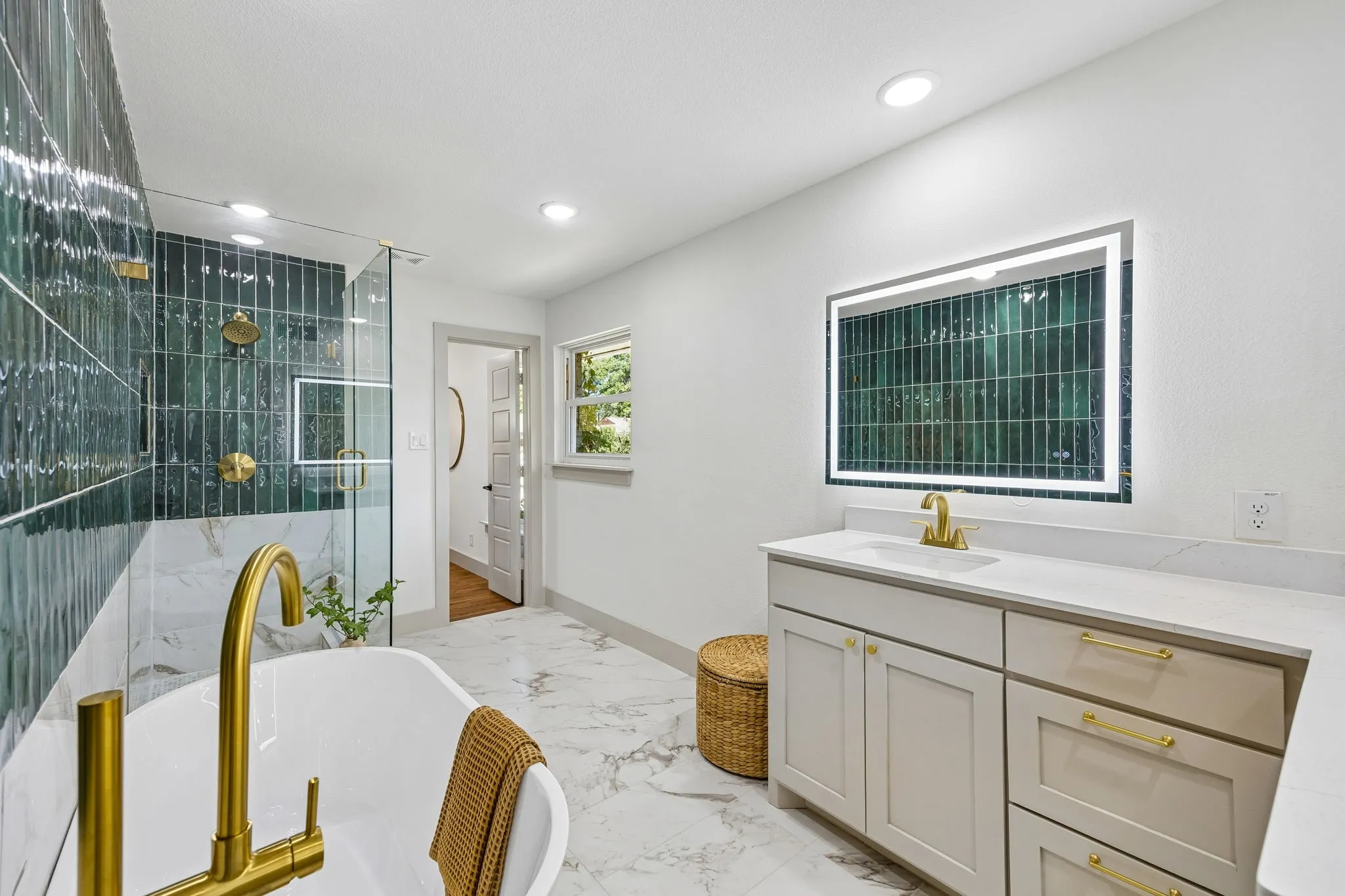 Freestanding soaking tub with a floor-mounted gold-finish faucet