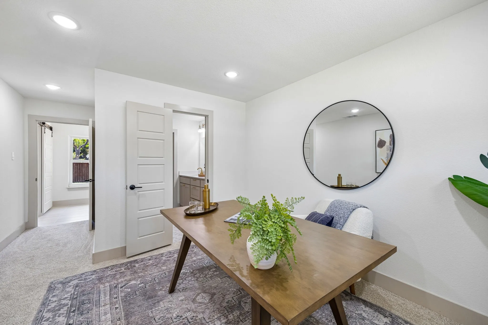 Recessed lighting, wood-finish table, white interior doors, and a neutral color palette