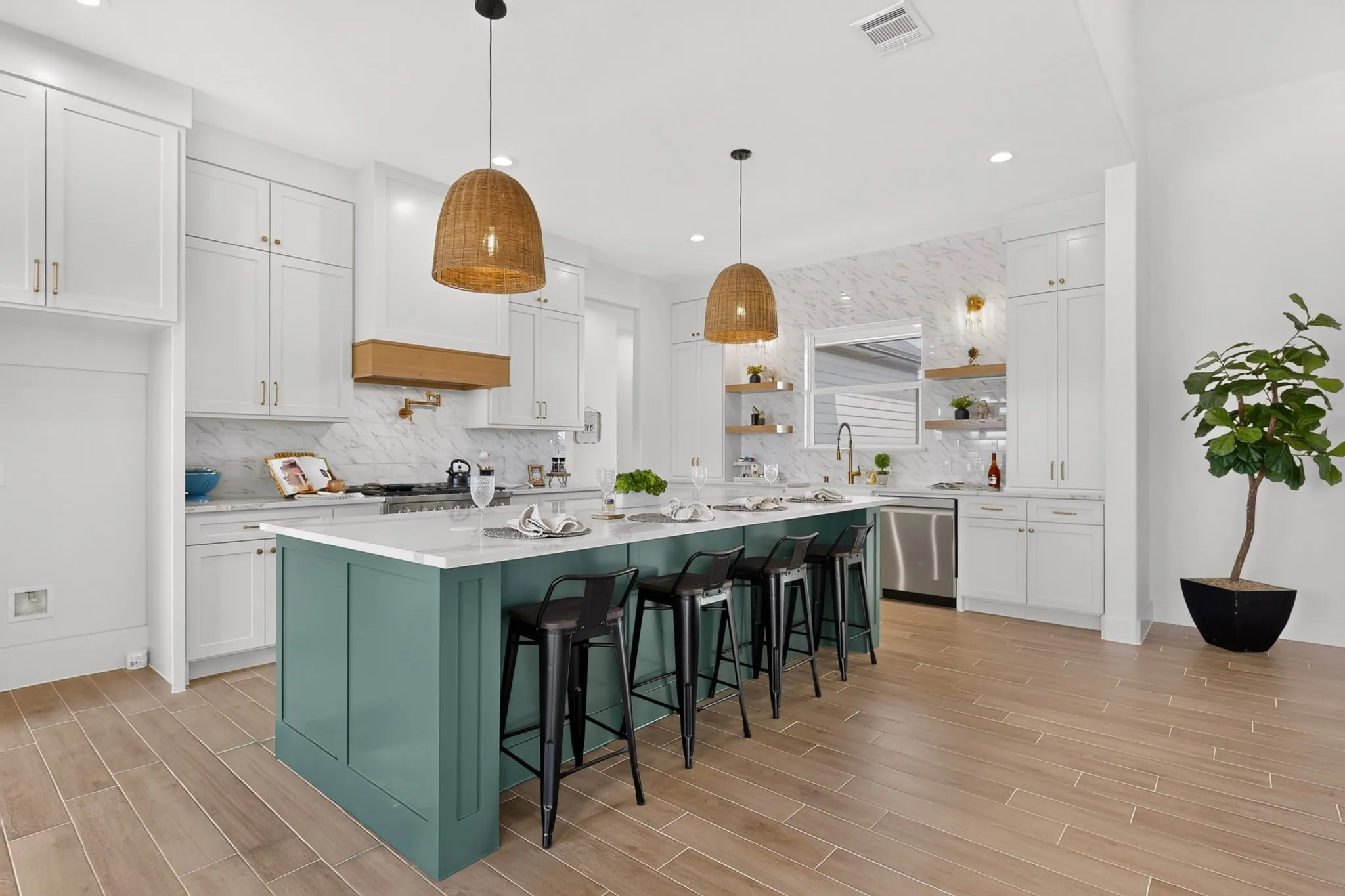 Kitchen featuring a large island with seating, white shaker-style cabinetry, wood-finish flooring, and stainless steel appliances