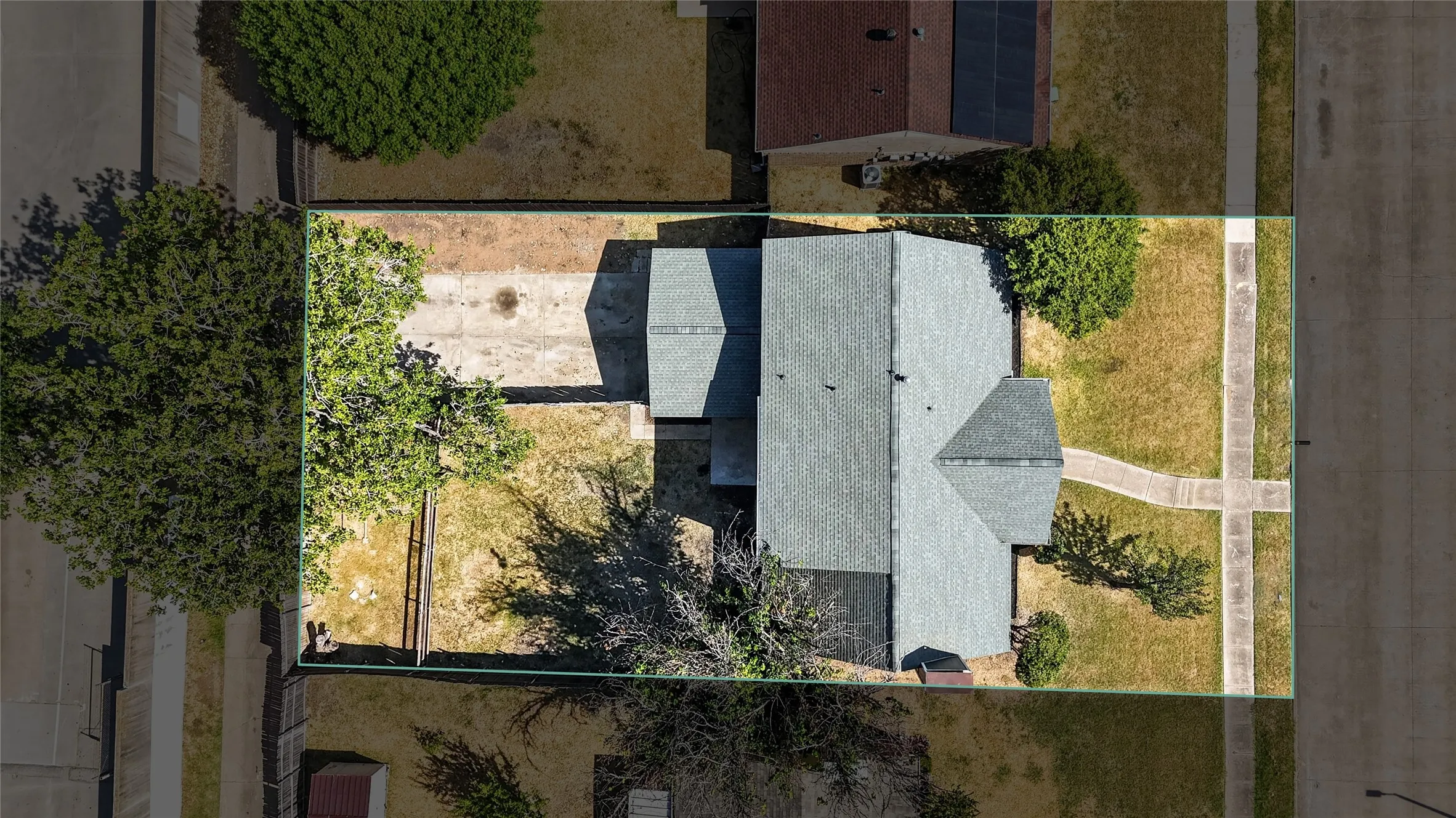 Pitched roofline, mature trees, concrete driveway, front walkway, established neighborhood setting