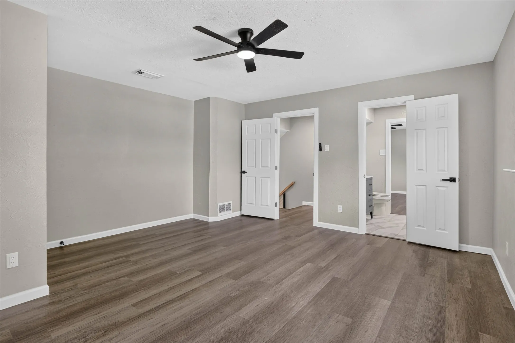 Wood-finish flooring, recessed ceiling fan with integrated lighting, painted walls, and white trim throughout