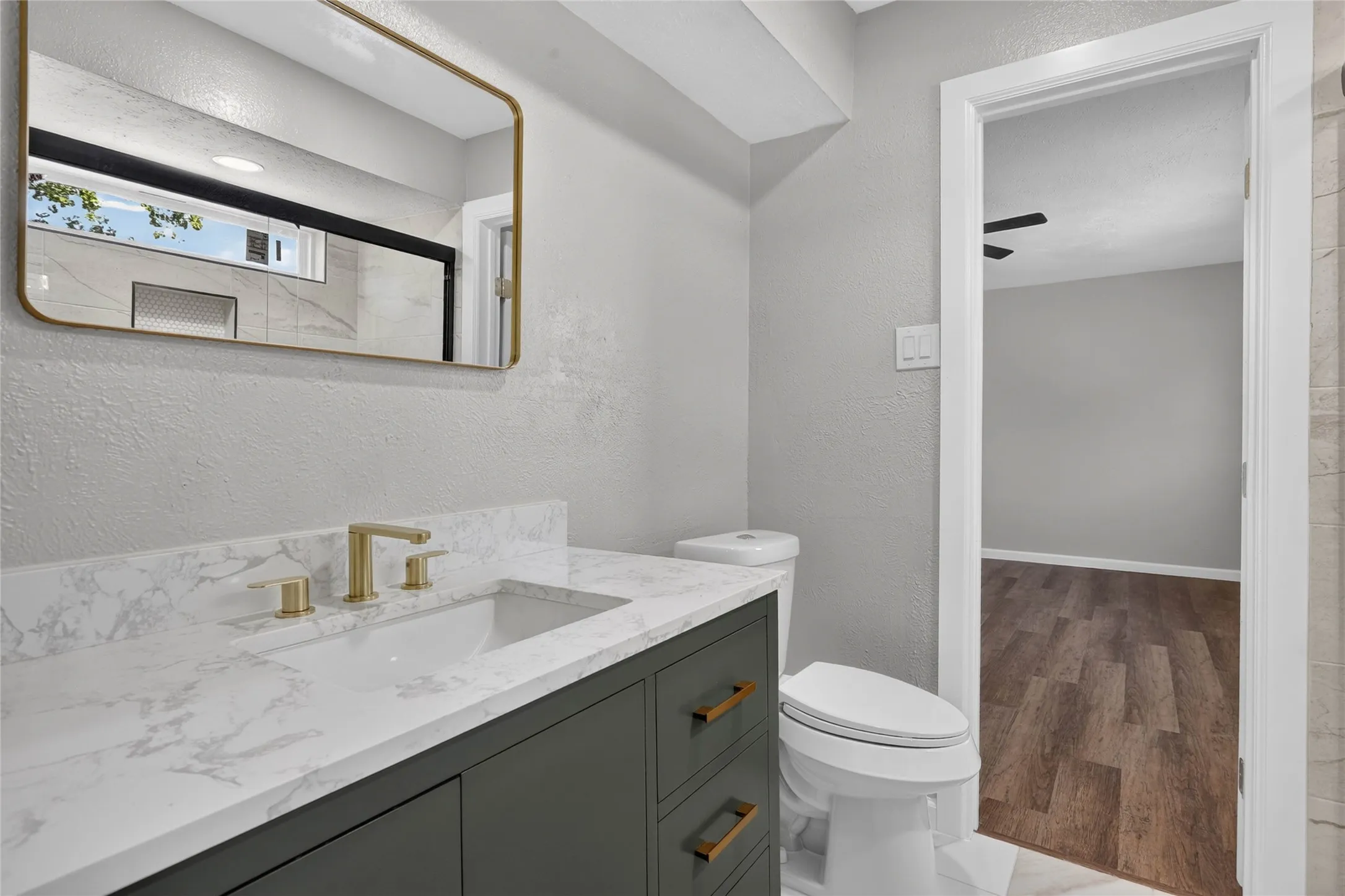 Modern vanity with stone-look countertop, undermount sink, and gold-finish fixtures