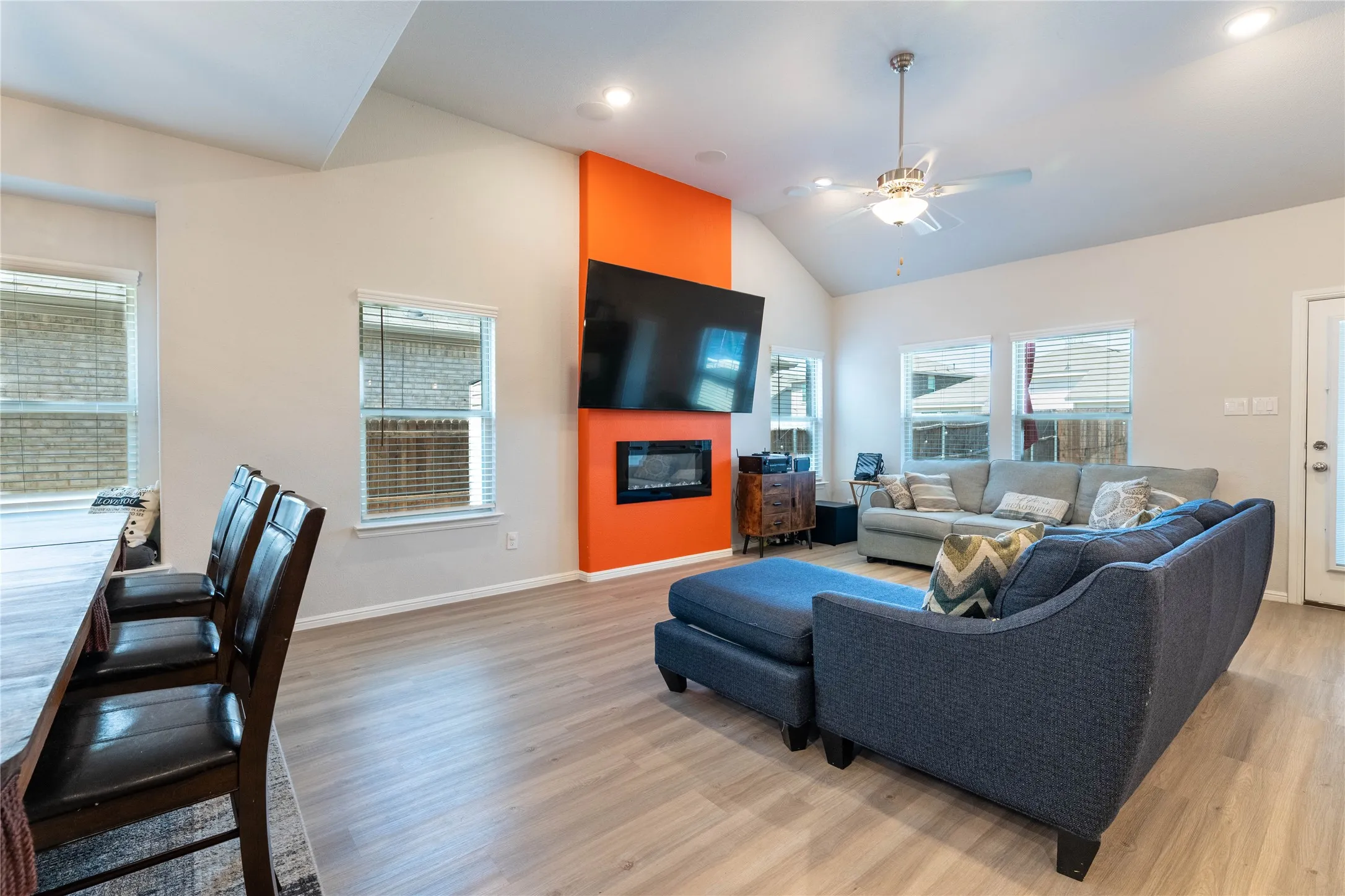 Vaulted ceiling, recessed lighting, wood-finish flooring, accent wall, built-in fireplace