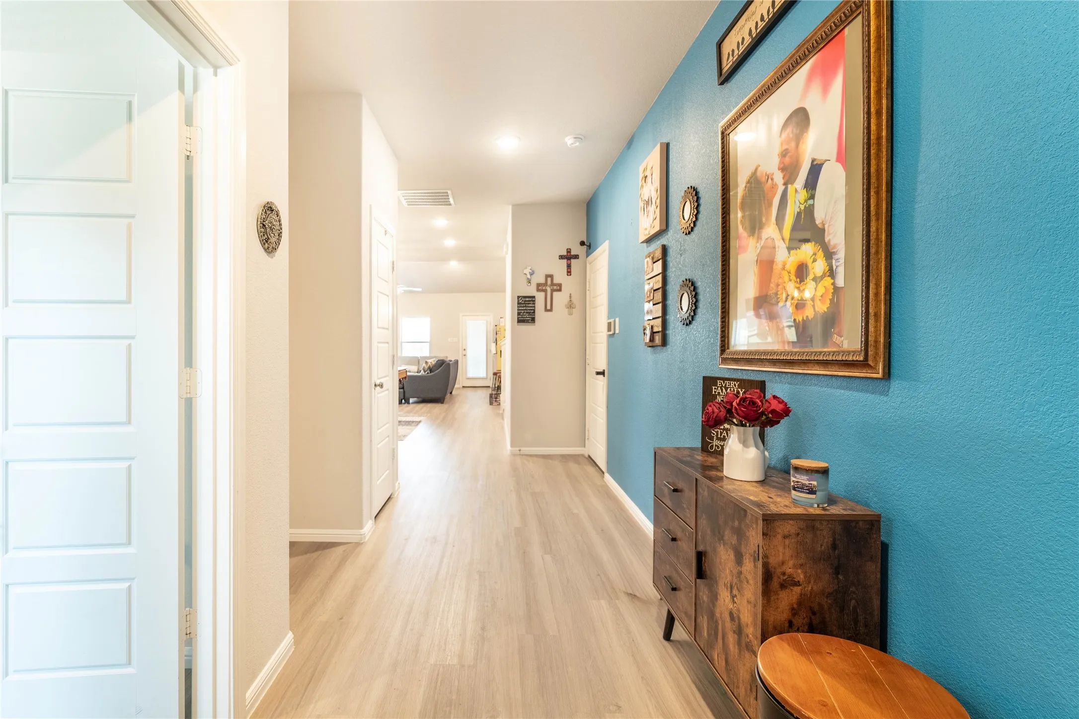 Bright hallway with wood-finish flooring, recessed lighting, and panel interior doors