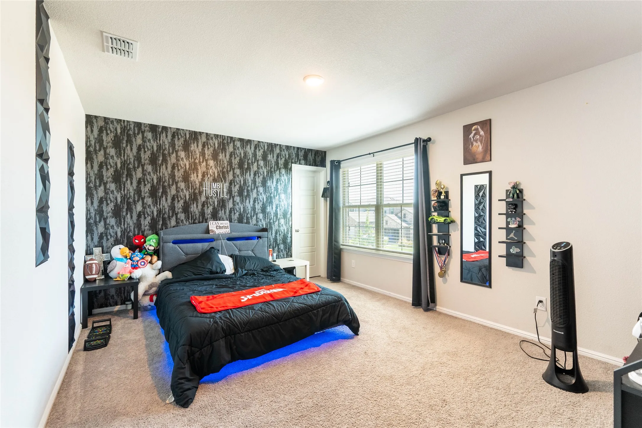 Wall-to-wall carpeting, window with horizontal blinds, built-in recessed lighting, and a textured accent wall