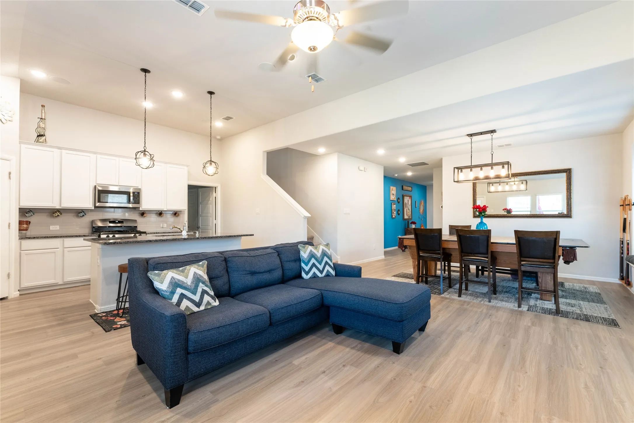 Open-concept living space featuring wood-finish flooring, recessed lighting, and a ceiling fan