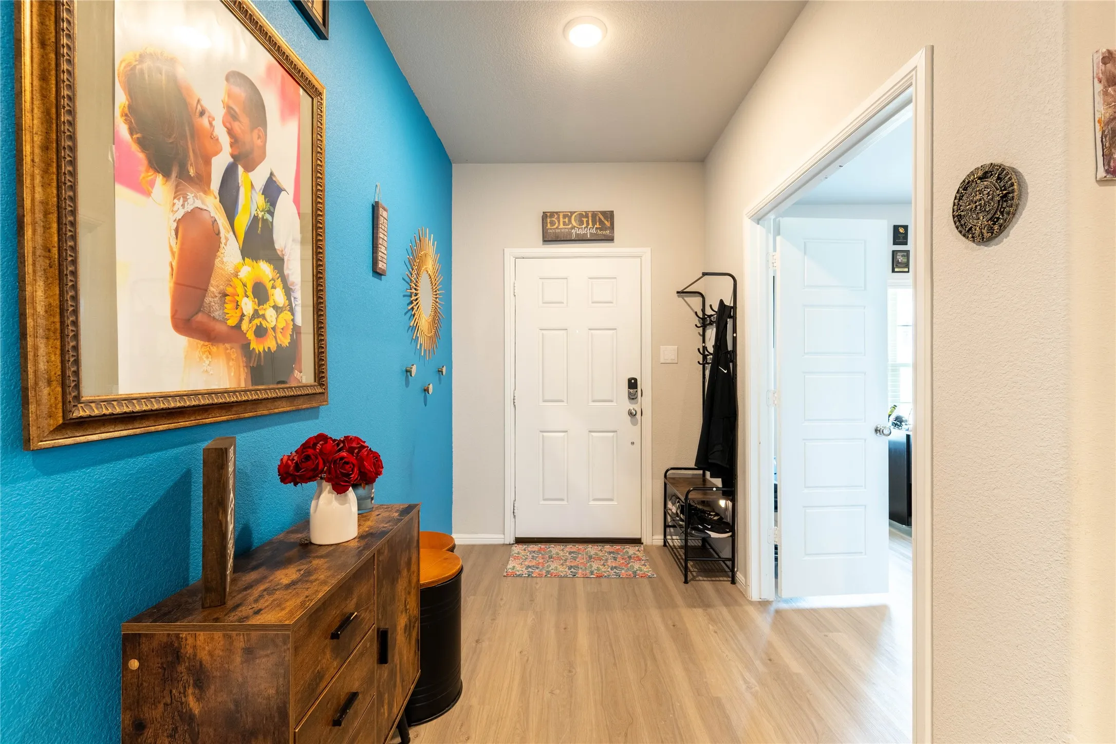 Wood-finish flooring with a multi-panel interior door, recessed lighting, and a paneled entry door