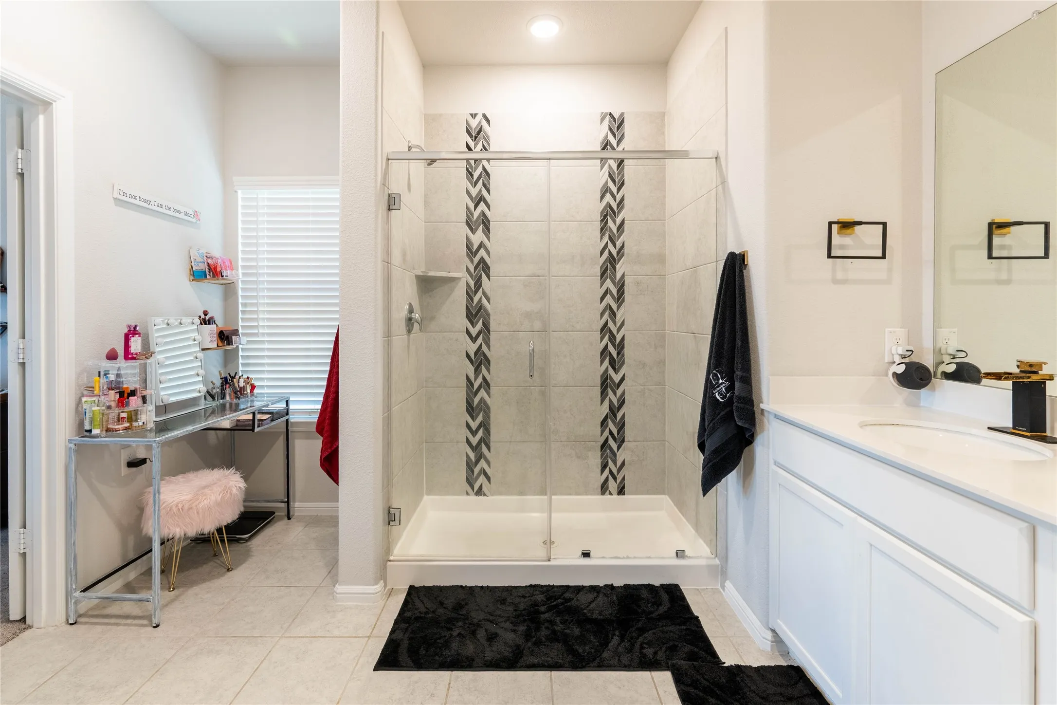Glass-enclosed shower with a decorative tile inlay and a built-in shower niche