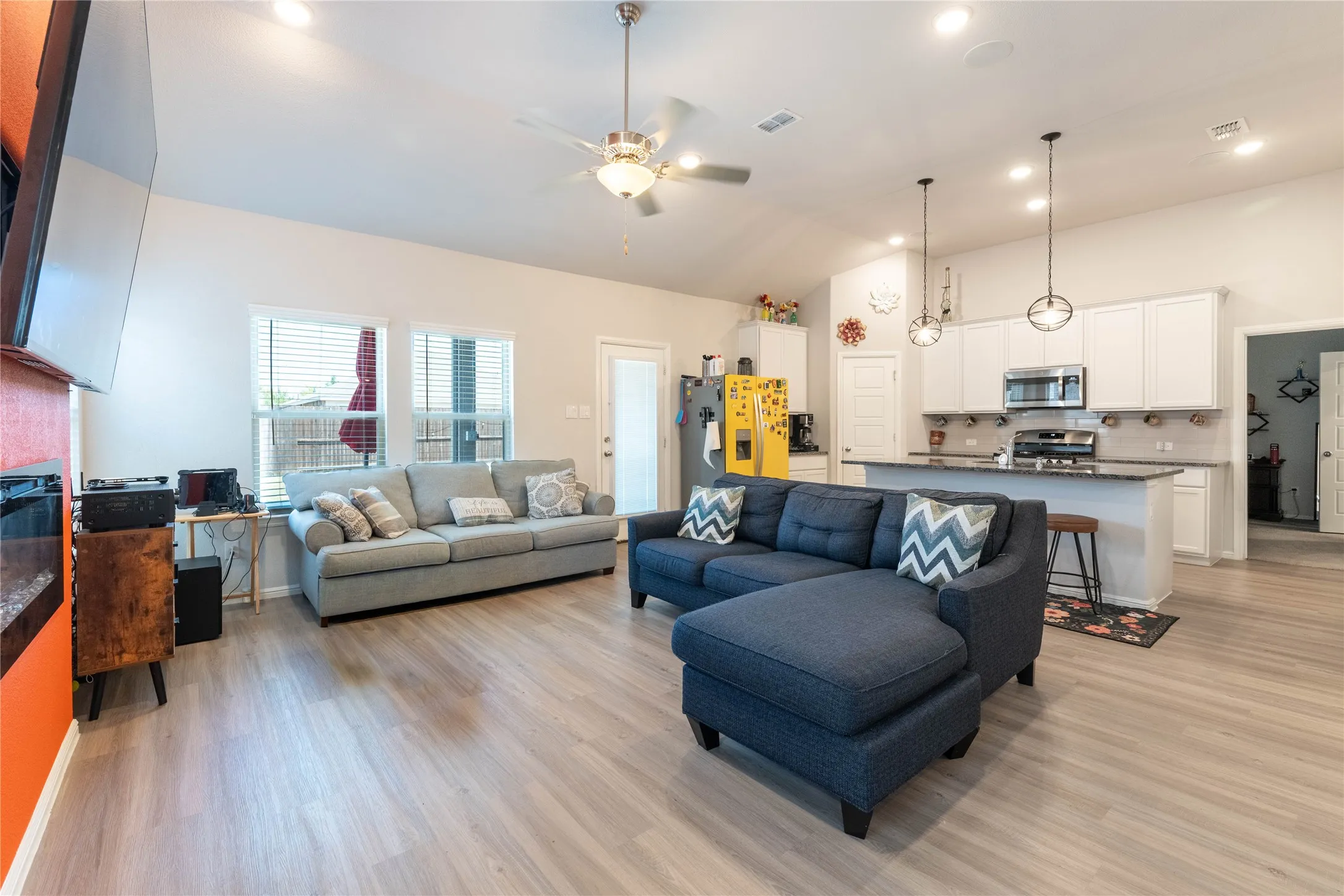 Open-concept living space featuring wood-finish flooring, recessed lighting, and a ceiling fan