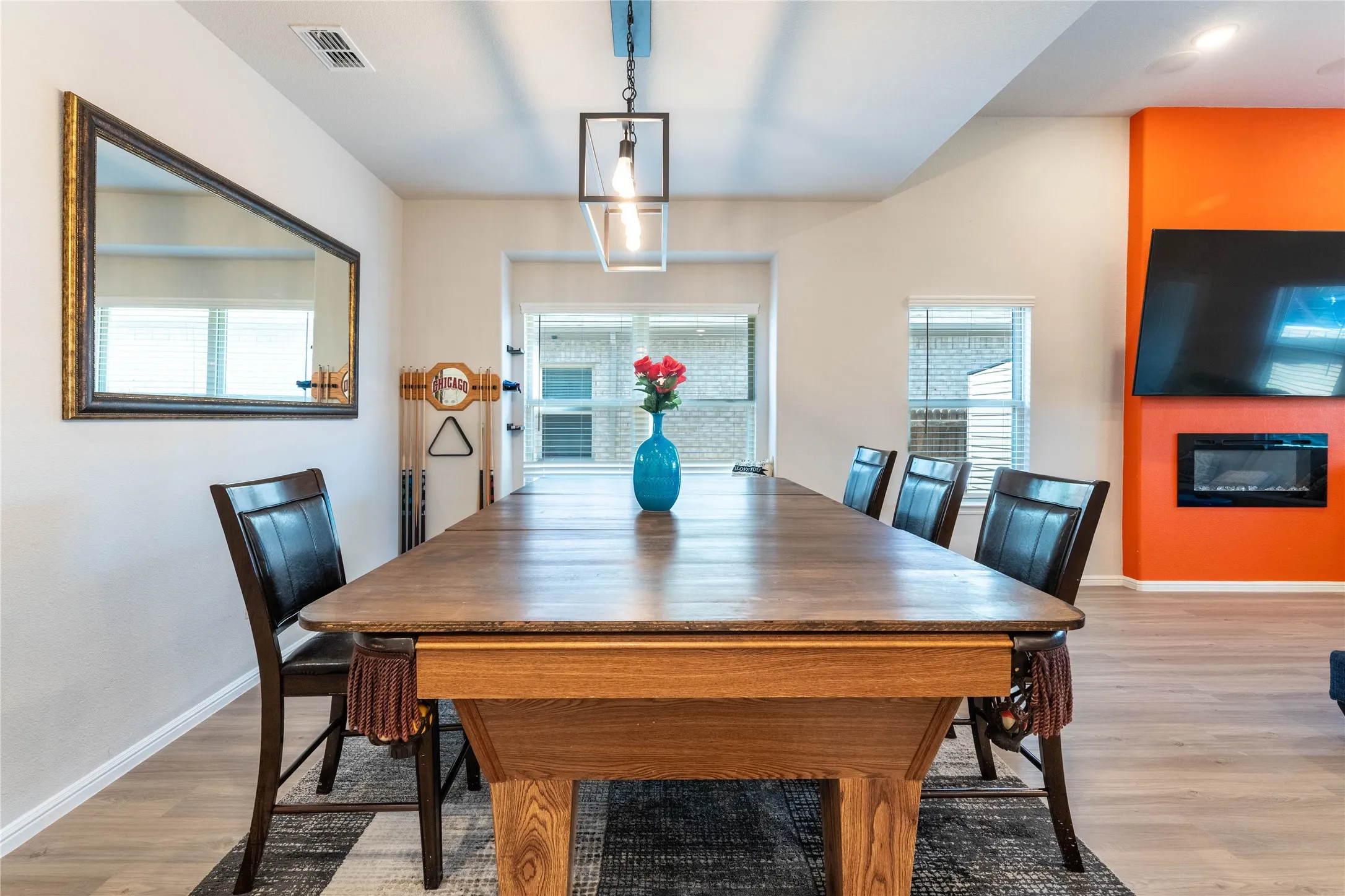 Light wood-finish flooring with an accent wall featuring an electric fireplace
