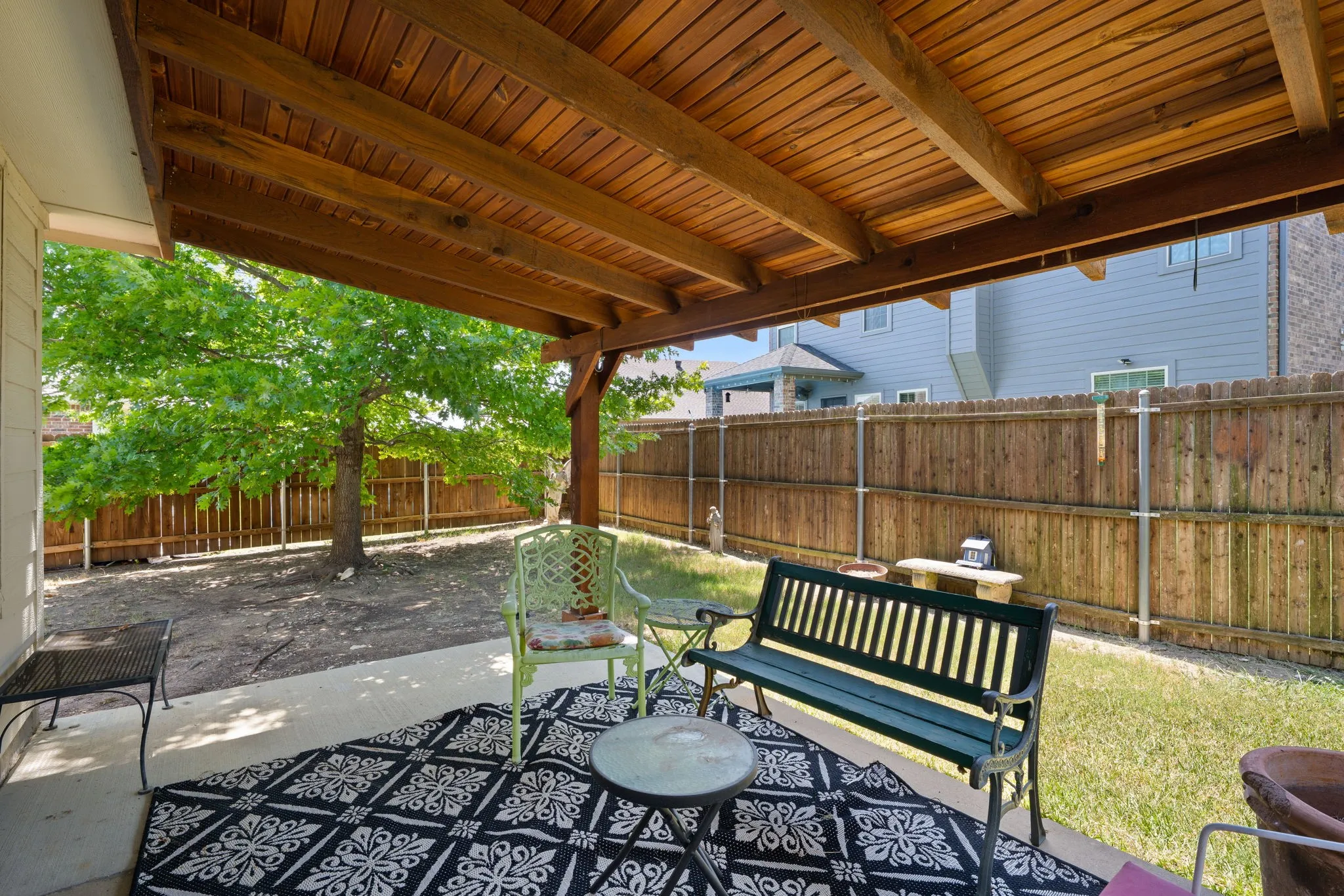 Covered patio with a wood-finish ceiling, concrete flooring, and a privacy fence