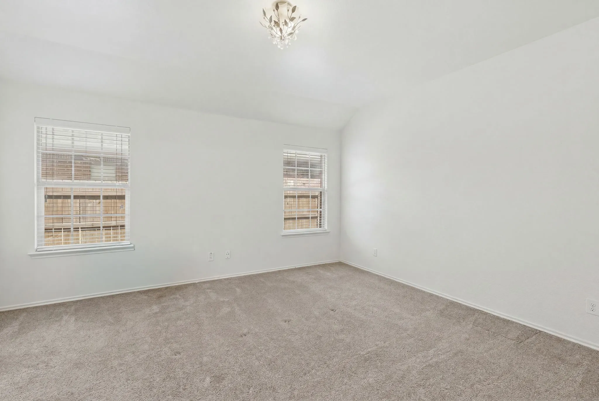 Neutral wall paint, two windows with blinds, and a built-in ceiling light fixture