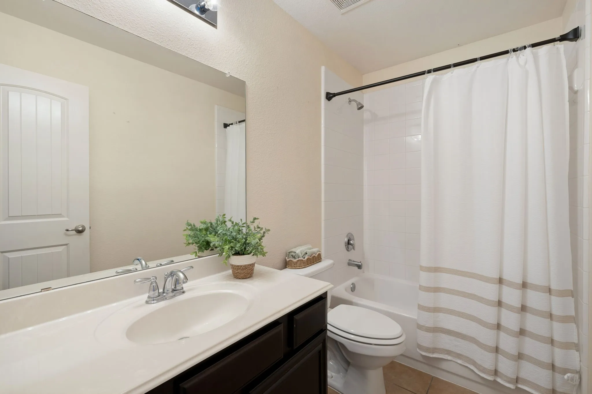 White vanity with an integrated sink, chrome faucet, and expansive wall mirror