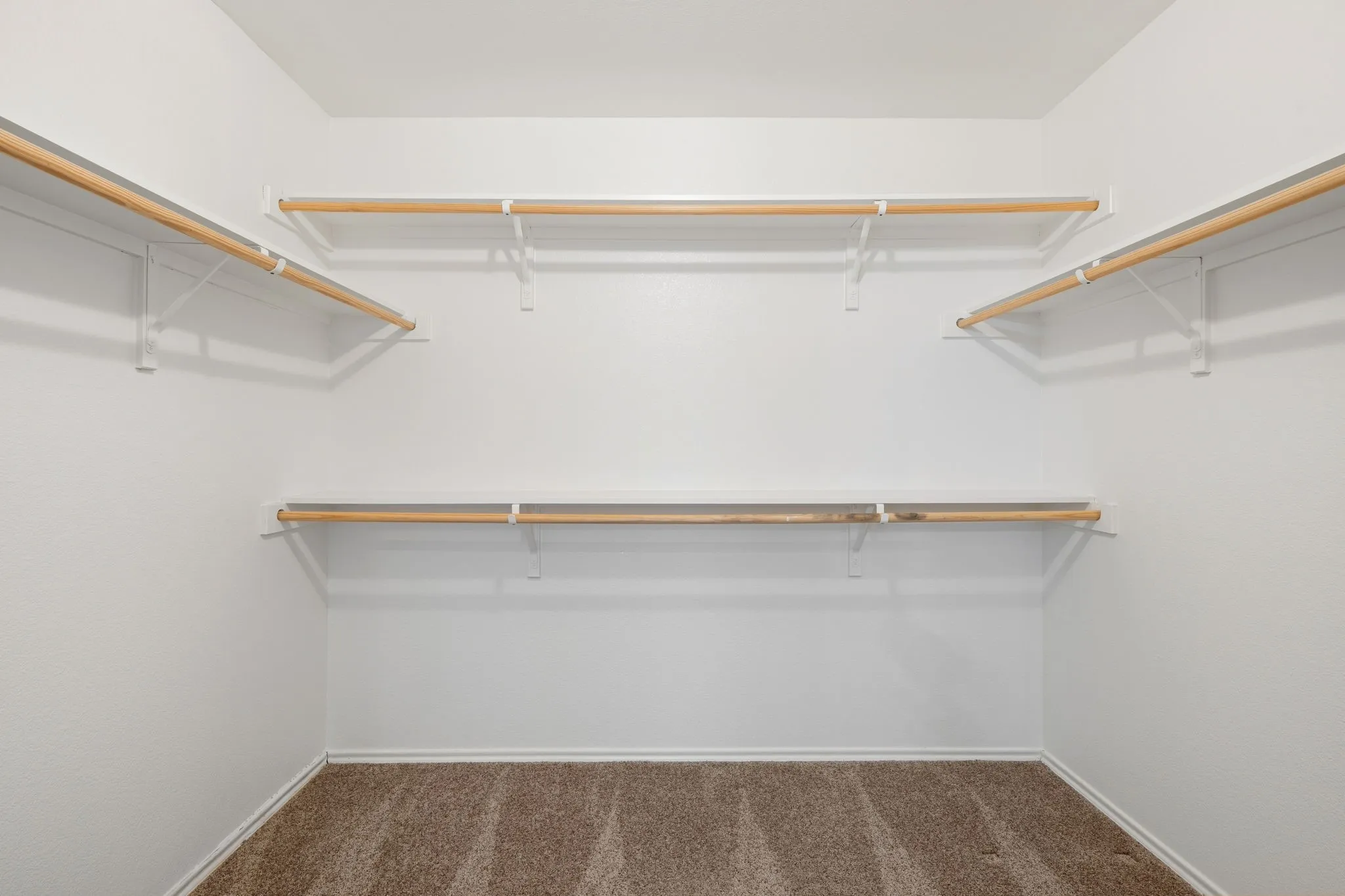 Walk-in closet with multiple hanging rods and integrated shelving