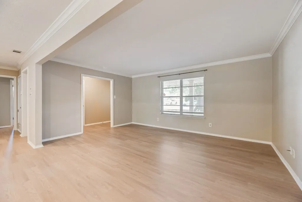 Spacious front living area showcases brand-new LVP flooring, fresh neutral paint and abundant natural light. The open layout provides a versatile blank canvas ready to fit your personal style.