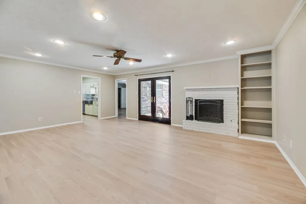 The spacious second living area features a gas fireplace, built-in shelving and French doors leading to the backyard. Recessed lighting and a ceiling fan complete this comfortable gathering space.