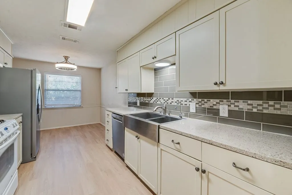 The kitchen offers granite countertops, abundant cabinetry, stainless steel appliances and a statement farmhouse-style sink. Generous counter space provides plenty of room for meal prep and everyday functionality.