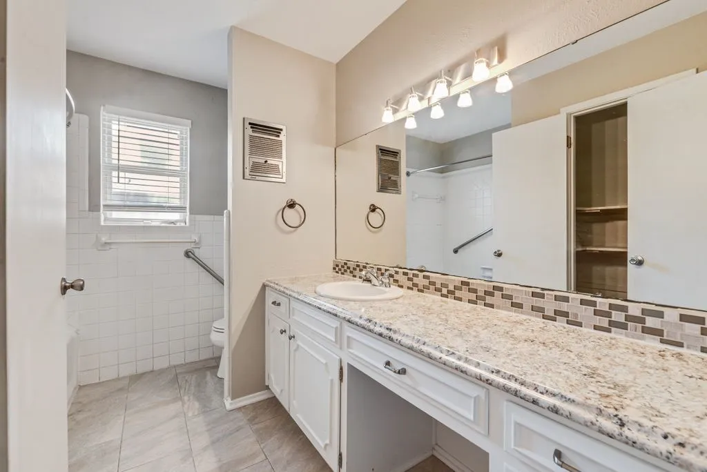 The shared bathroom features a spacious vanity with ample counter space, a tub-shower combination and dedicated linen closet for convenient storage.