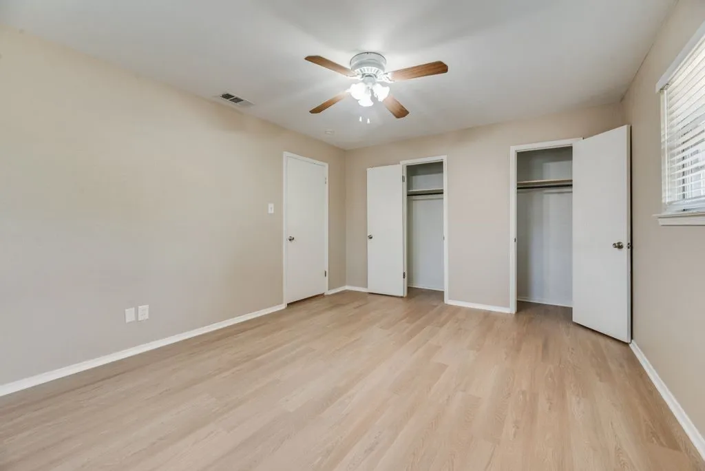Bedroom 2 offers generous space, brand-new LVP flooring, two windows for natural light and a ceiling fan for added comfort.