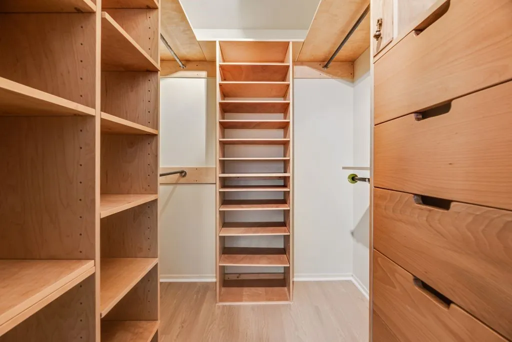 The primary walk-in closet is outfitted with extensive built-in shelving, hanging space and drawers, providing exceptional organization and storage.