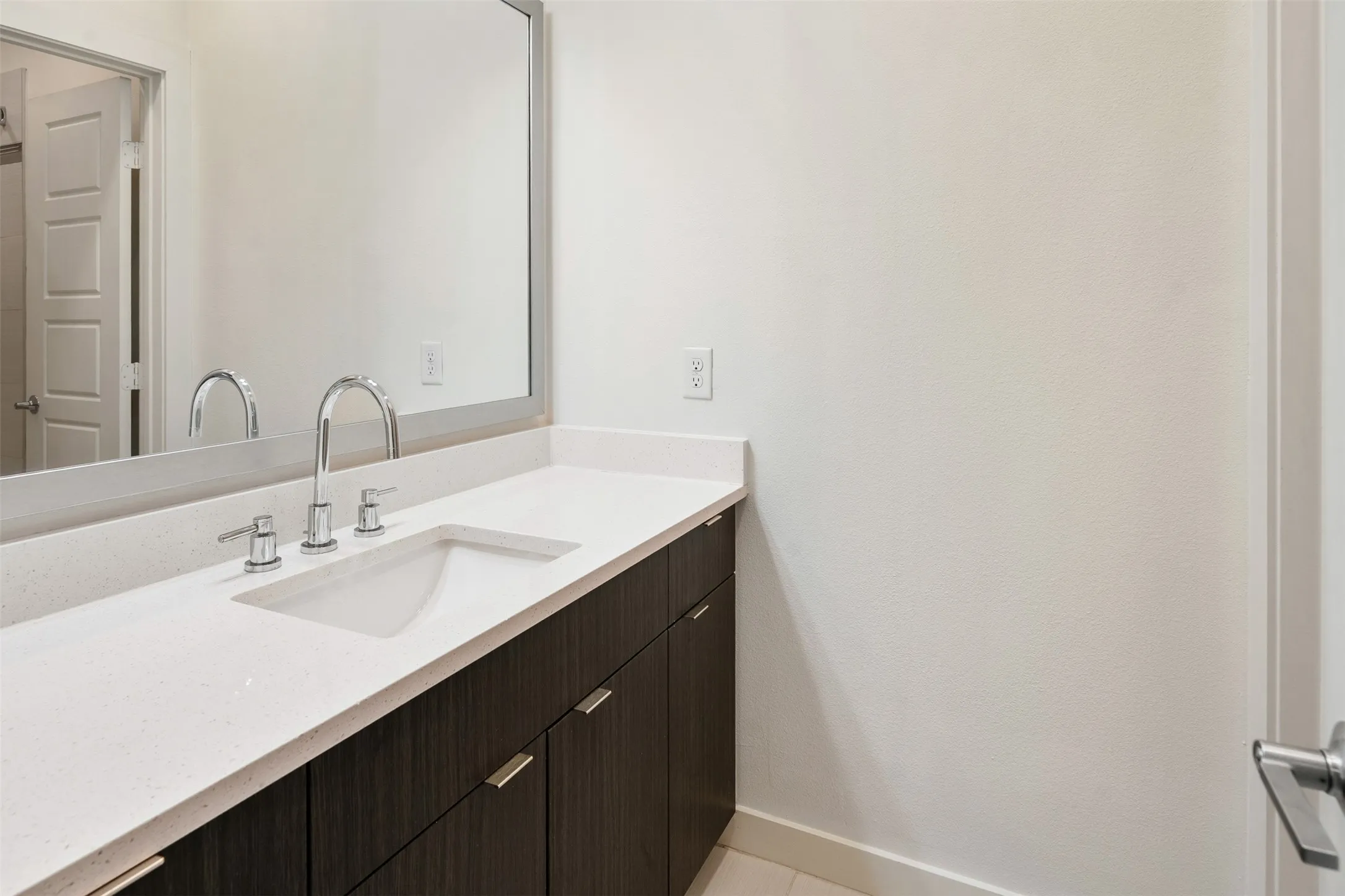 Floating vanity with a light-toned countertop, undermount sink, and chrome fixtures
