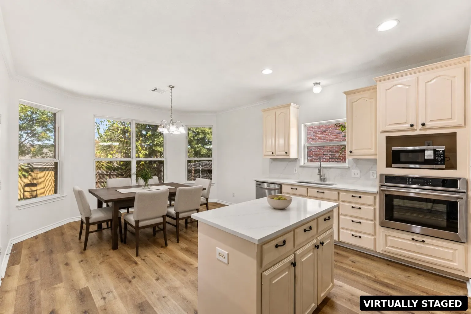 Expansive wood-finish flooring, recessed lighting, and a kitchen island with storage