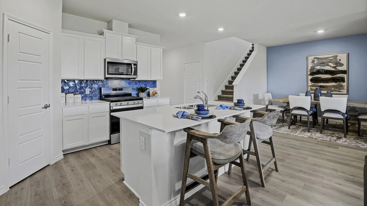 White kitchen cabinetry with a blue hexagonal tile backsplash