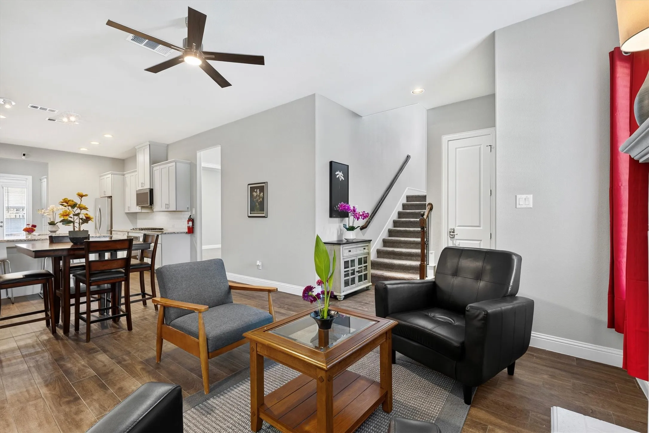 Contemporary living area with wood-finish flooring, recessed lighting, and a ceiling fan