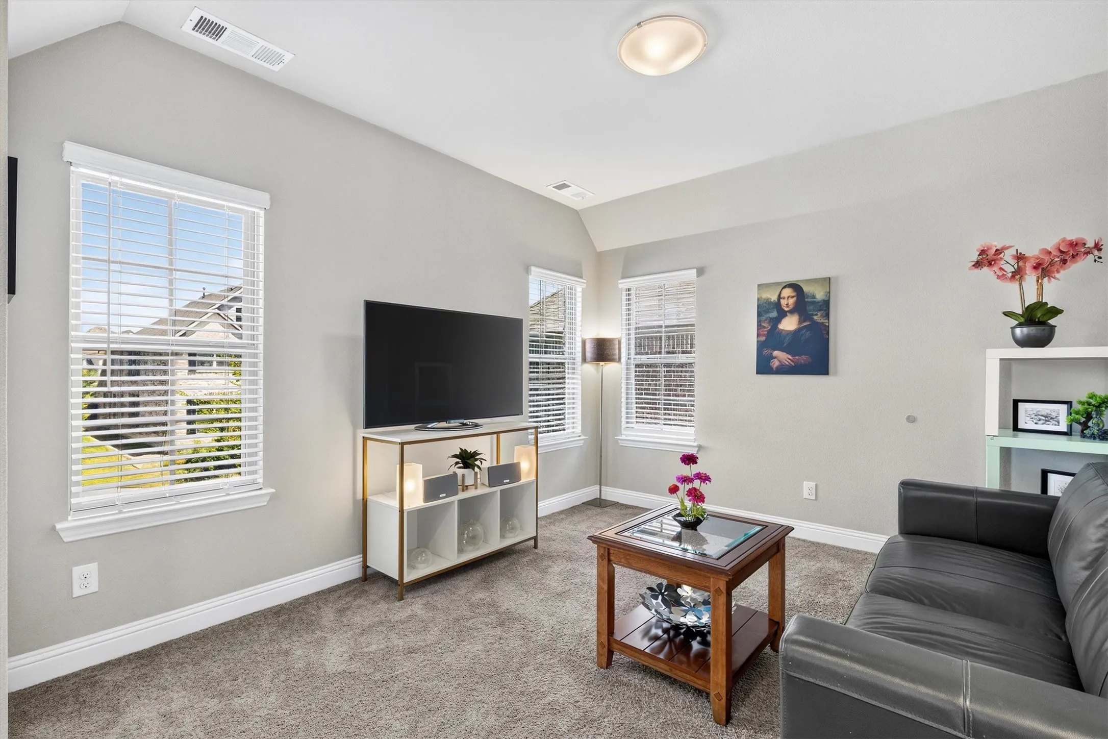 Carpeted flooring, vaulted ceiling, recessed lighting, multiple windows with blinds