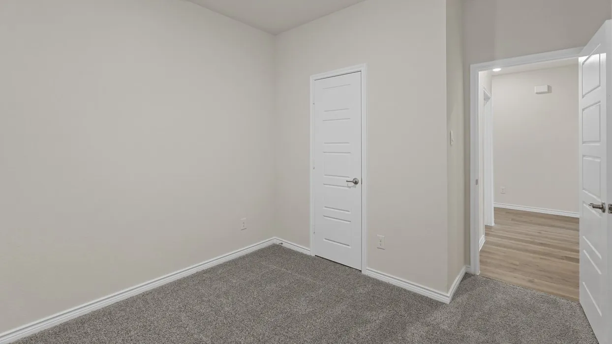 Light gray wall paint, gray carpet flooring, white trim, and white interior doors