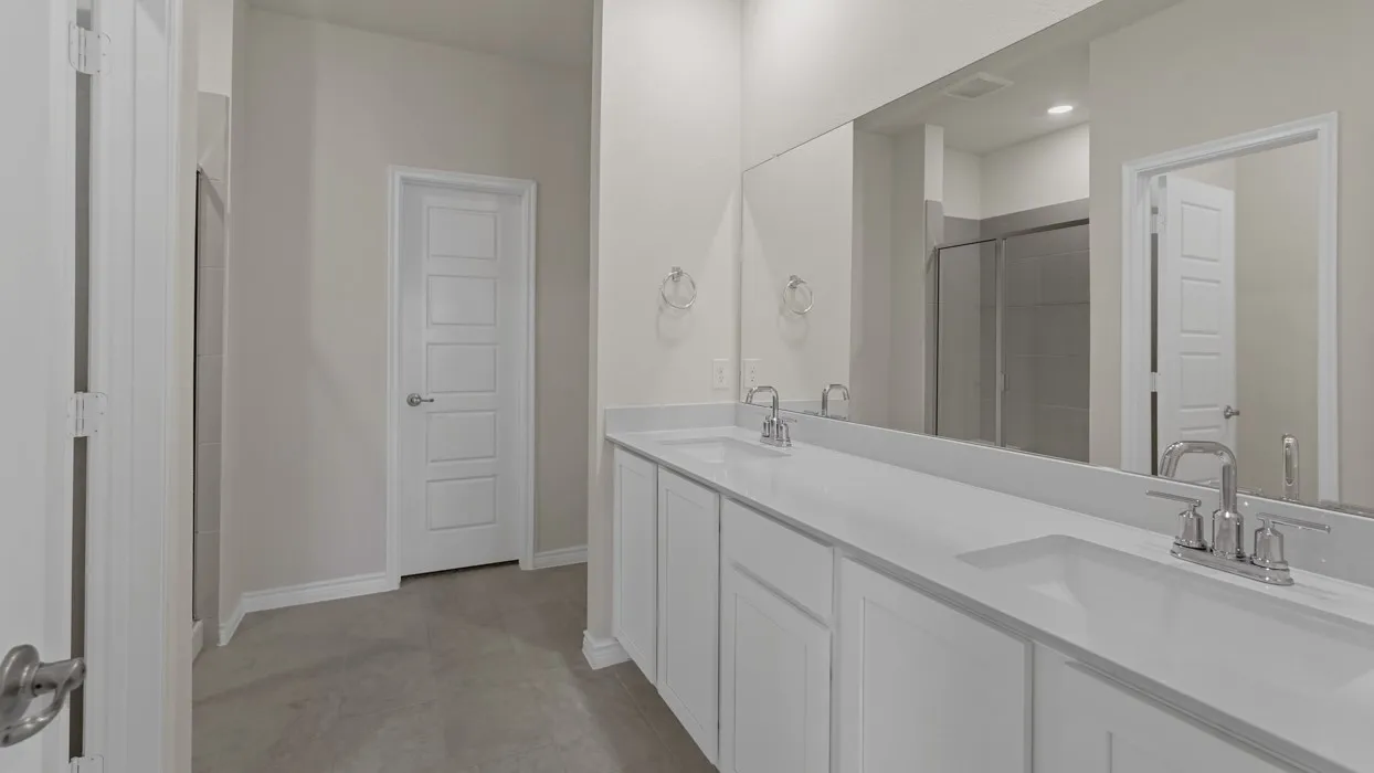 Dual vanity with integrated sinks, expansive mirror, and a glass-enclosed shower
