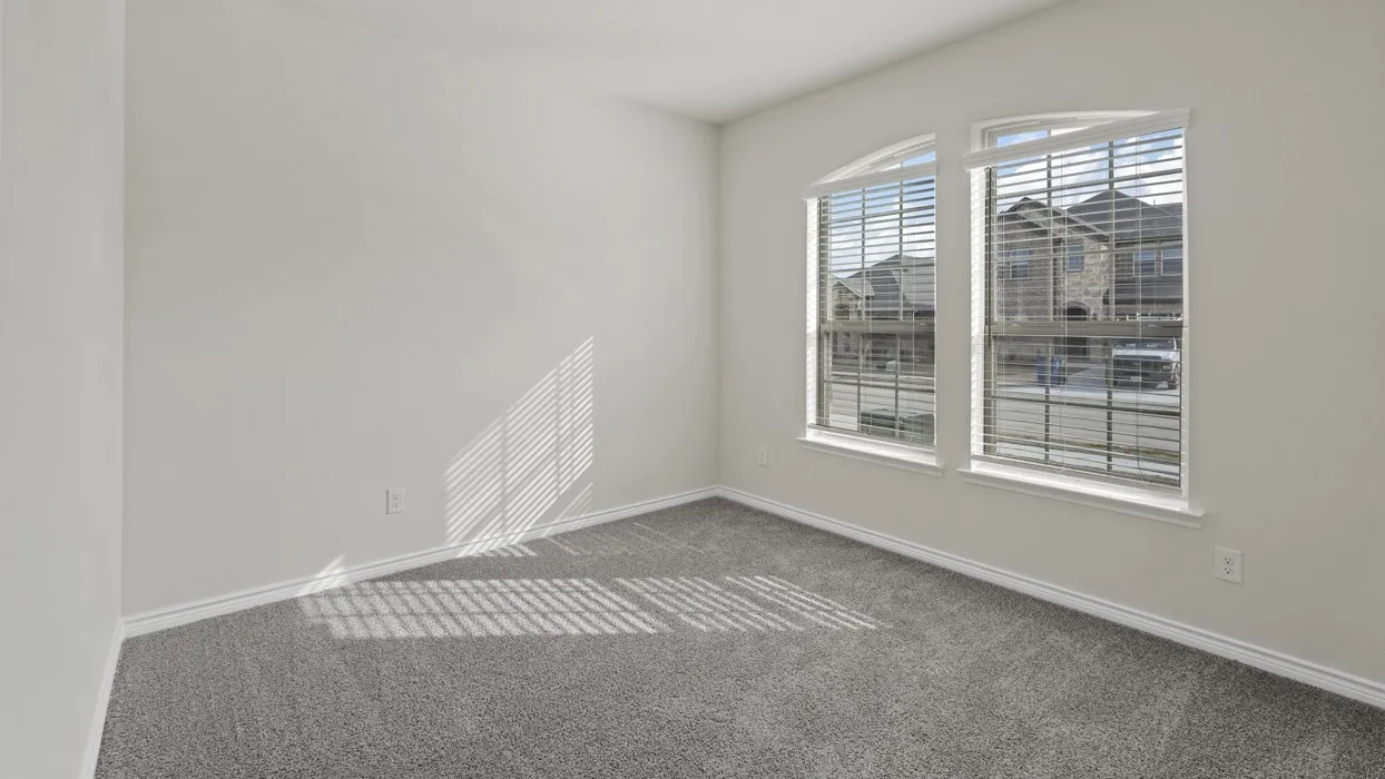 Neutral wall color, arched windows, window blinds, and gray carpeting