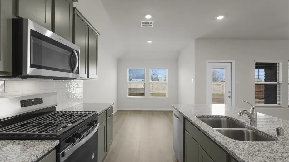 Kitchen featuring stainless steel appliances, granite countertops, gray cabinetry, and wood-finish flooring