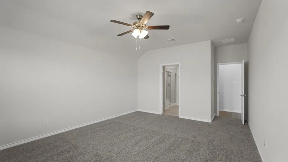 Spacious room with light gray walls, gray carpeting, and a ceiling fan with integrated lighting