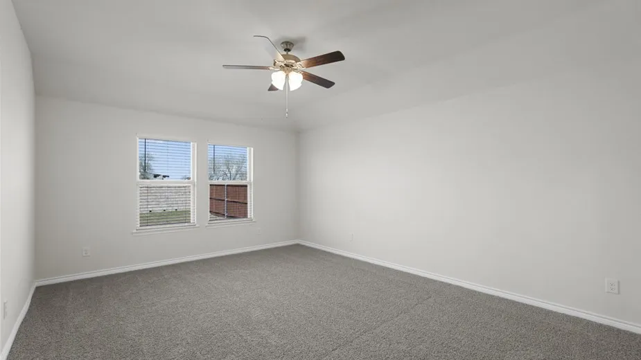 Neutral wall color, soft gray carpeting, ceiling fan with integrated lighting, and two windows