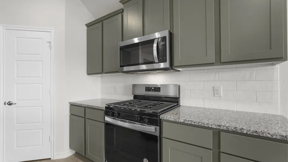 Kitchen featuring gray cabinetry, granite countertops, stainless steel appliances, a gas range, and a white subway tile backsplash